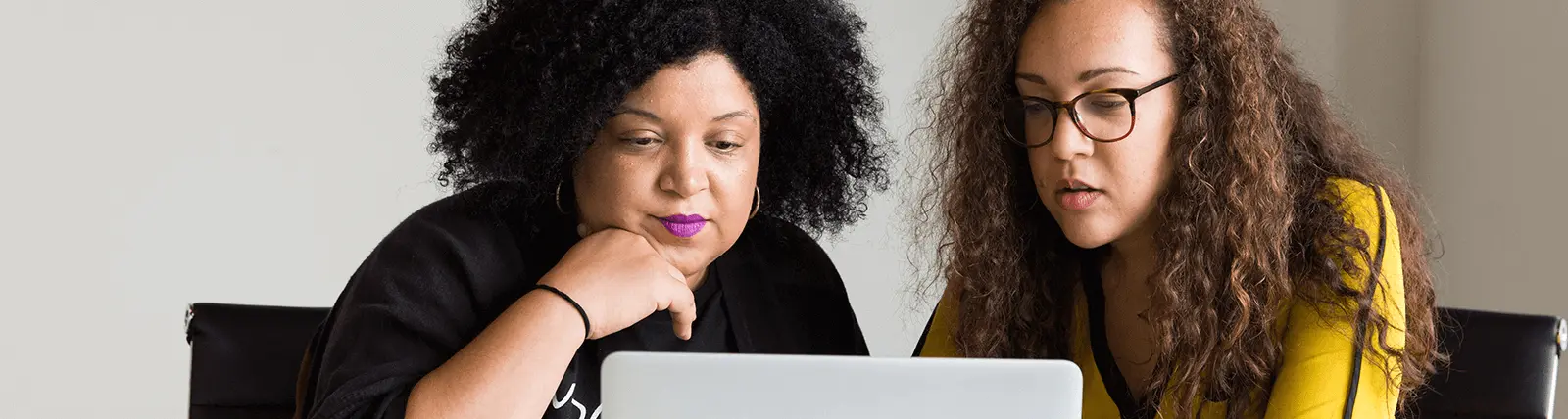 Two women working on a laptop