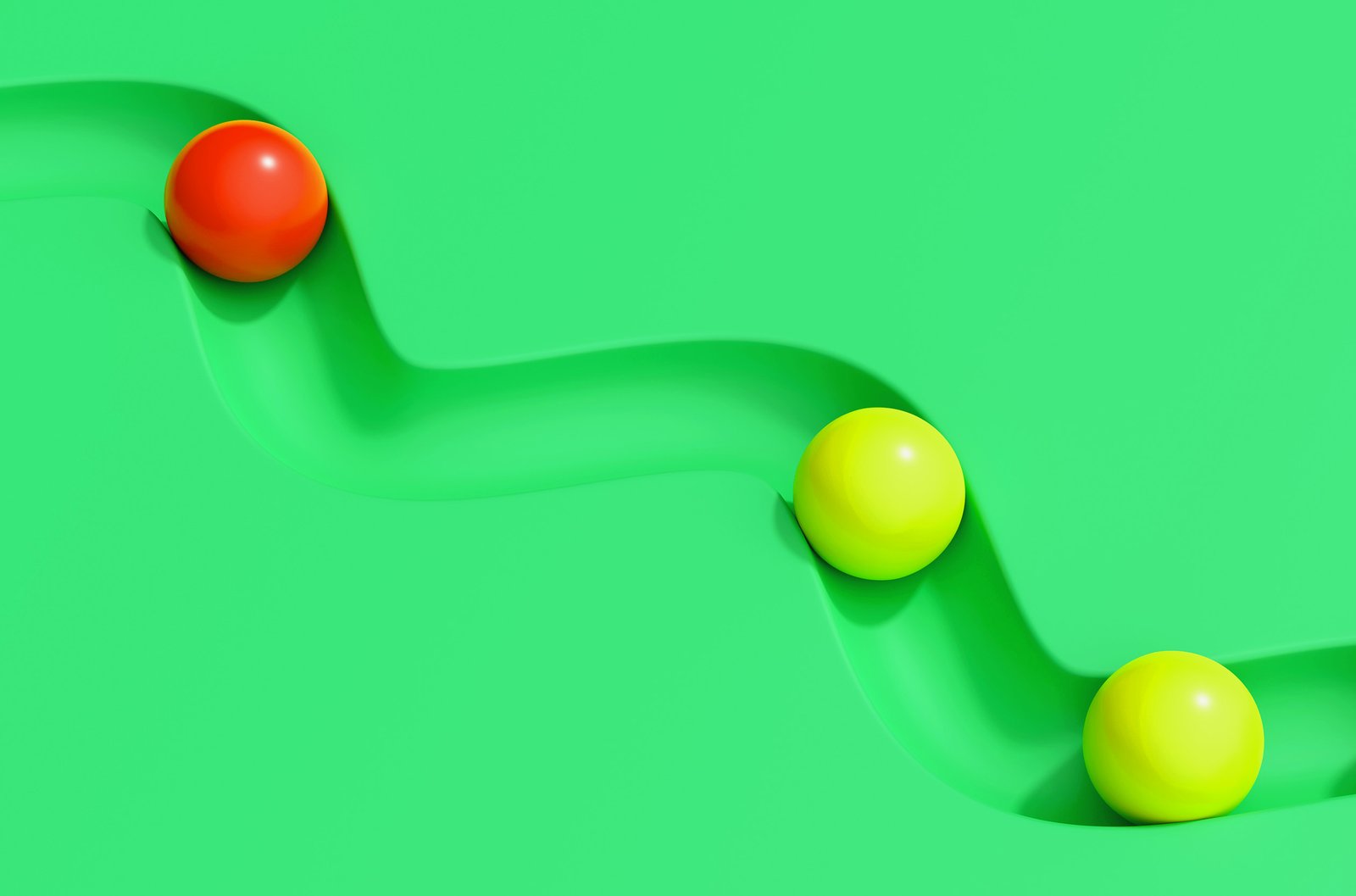Red and yellow spheres rolling through a track