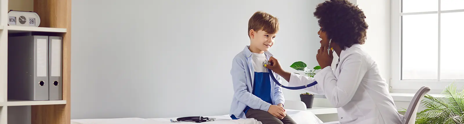 Doctor with stethoscope listening to young patient's heart