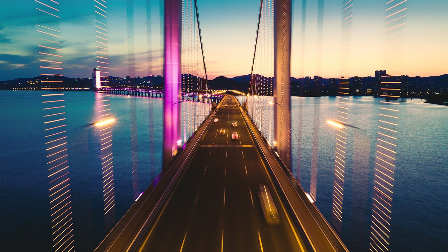 Cars travelling across a suspended bridge at dusk