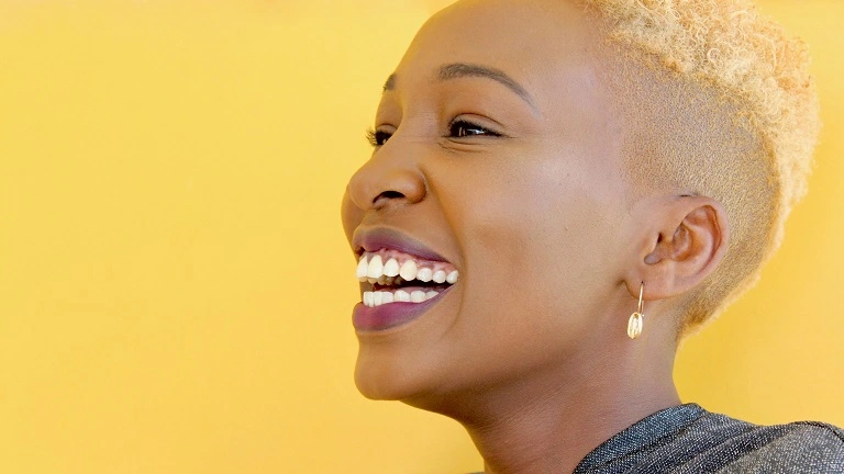 Woman smiling against a yellow background