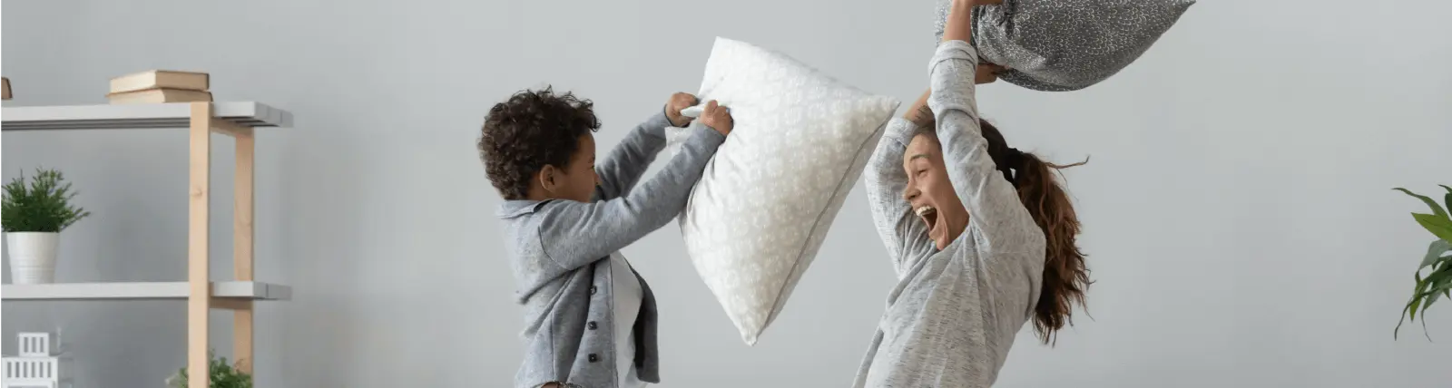 A mother and child having a pillow fight