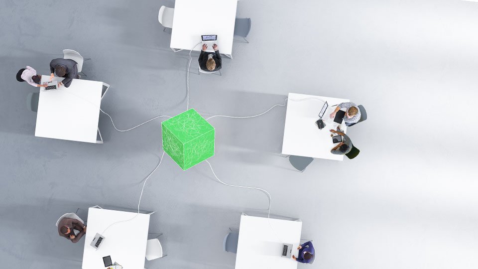 Workstations connected to a green cube